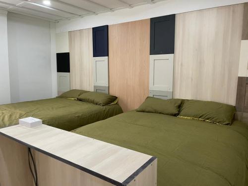 ein Zimmer mit 2 Betten und einer Theke darin in der Unterkunft PartyPad Newcastle in Saint Peters