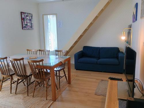 a living room with a table and a blue couch at Proche Paris,Cosy appartement, 3 bedrooms in Saint-Ouen