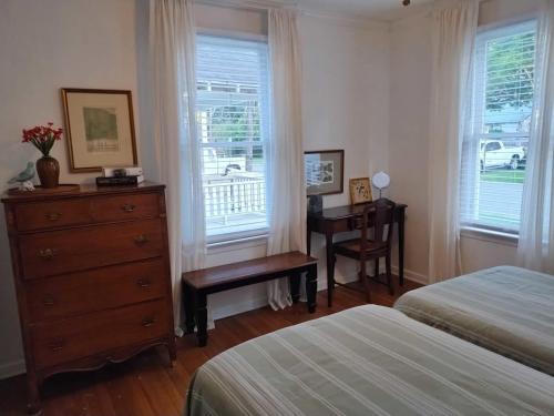 a bedroom with a dresser and a bed and a desk at Charming Hideaway in Lafayette