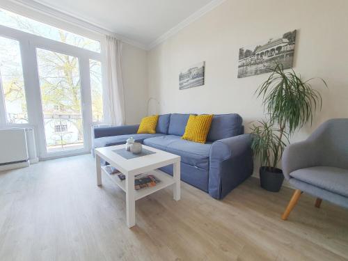 a living room with a blue couch and a table at Ferienwohnung Stadtvilla - charmante Gemütlichkeit in Bad Oldesloe
