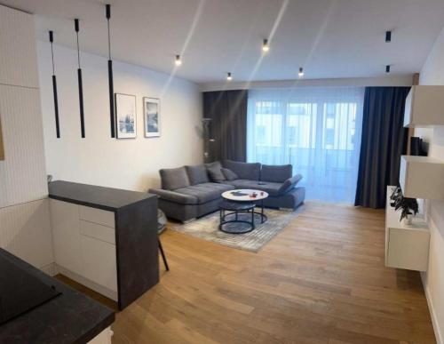 a living room with a couch and a table at Apartaments Airport Komputerowa Premium in Warsaw