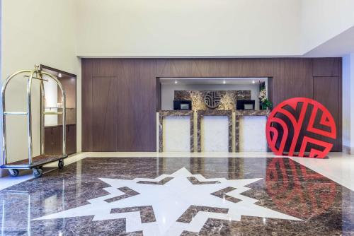 a lobby with a red chair and a wall at NH Collection Bogota Andino Royal in Bogotá