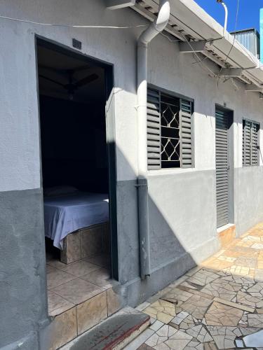 a building with a window and a bed in it at Pousada Sol in Goiânia