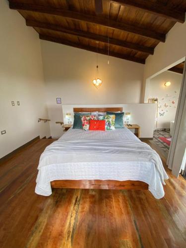 a bedroom with a large bed with a wooden floor at Villas Flakis, Vela in Monteverde Costa Rica