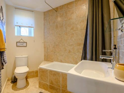 a bathroom with a toilet and a tub and a sink at 2 Bed in Crickhowell 90346 in Crickhowell