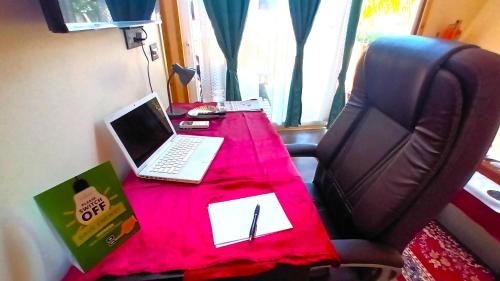 a desk with a laptop on top of a chair at Chan Beach Resort & Hotel in Bahūr