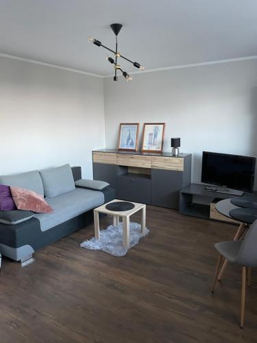 a living room with a couch and a table at Harmony Apartament in Suwałki