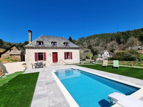 une grande piscine devant une maison dans l'établissement Gîte de France L'air du paradis 3 épis - Gîte de France 6 personnes MAE-6344, à Argentat
