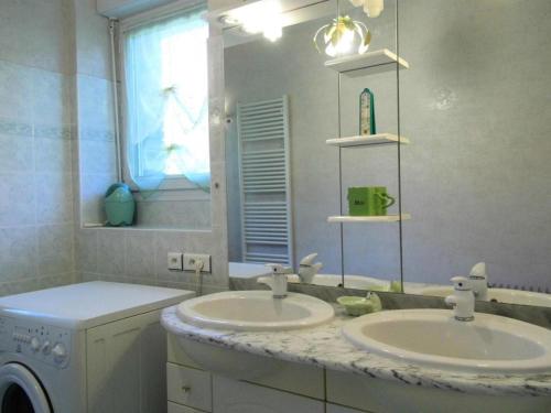 une salle de bain avec deux lavabos et une machine à laver dans l'établissement Gîte de France Gite de chouvert 