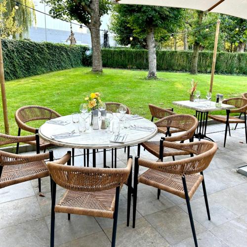 een groep tafels en stoelen in een tuin bij B&B Park Rodenbach in Roeselare