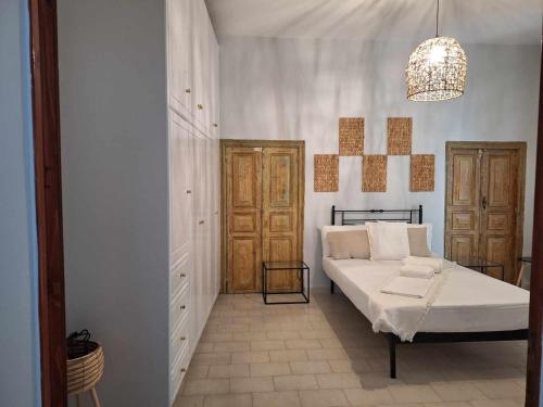 a bedroom with a bed and a chandelier at Melissa Chora in Koufonisia