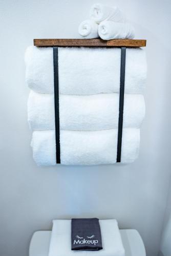 une pile de serviettes sur une étagère au-dessus des toilettes dans l'établissement Van Wormer Room 201, Hyland Hotel, à Palmer