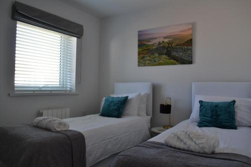 a bedroom with two beds and a window at Normsy Place Seaside Serenity Breath Taking Views in St Bees