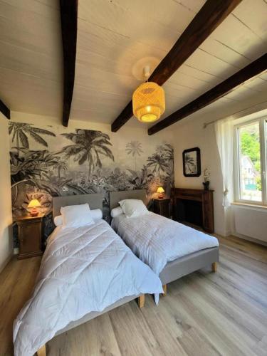une chambre avec deux lits et un mur avec des palmiers dans l'établissement Gîte de France Le grand air du paradis 3 épis - Gîte de France 9 personnes MAE-6464, à Argentat