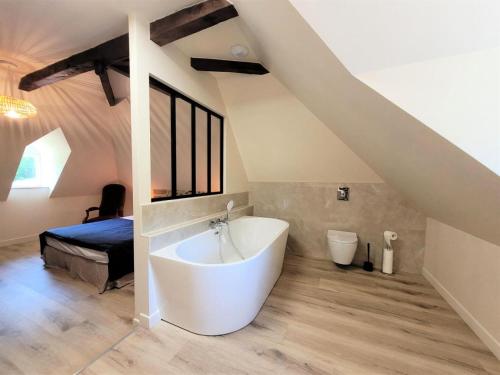 un bagno con una grande vasca bianca e un letto di Gîte de France Le grand air du paradis 3 épis - Gîte de France 9 personnes MAE-6464 ad Argentat