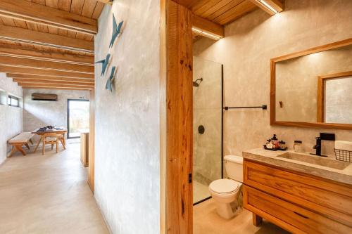 a bathroom with a toilet and a shower and a sink at Seabird Dwellings Villa with Private Splash Pool and Dock in Placencia Village