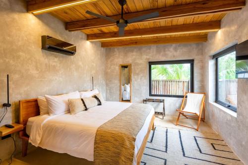1 dormitorio con 1 cama grande en una habitación en Seabird Dwellings Villa with Private Splash Pool and Dock, en Placencia Village