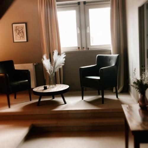 een woonkamer met 2 stoelen en een salontafel bij B&B Park Rodenbach in Roeselare