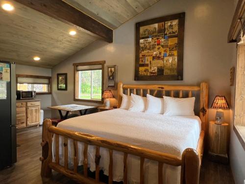 a bedroom with a large bed and a kitchen at Fort Williamson Glacier Vacation Rentals in Columbia Falls