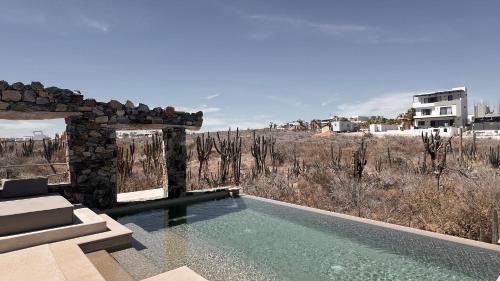 a swimming pool with a view of a field at Desierto Azul in Todos Santos