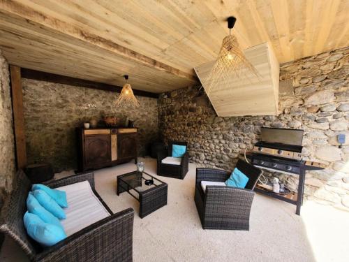 a living room with furniture and a stone wall at Gîte de France Gîte le petit air 3 épis - Gîte de France 3 personnes MAE-6624 in Argentat