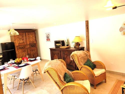 a living room with wicker chairs and a table at Gîte de France Gîte le petit air 3 épis - Gîte de France 3 personnes MAE-6624 in Argentat