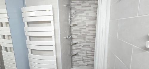 a bathroom with a shower with white towels at Villa dans résidence avec piscine , stationnement proche de la mer in Vendres