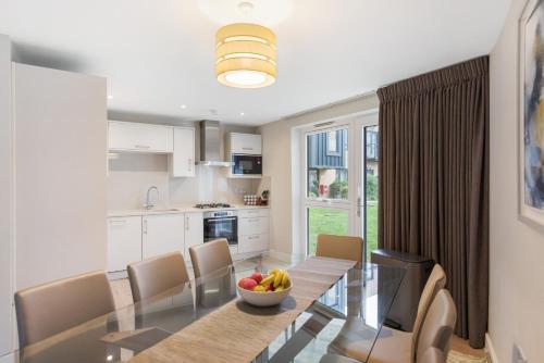a kitchen and dining room with a table and chairs at Modern 3BR Flat quick links to LDN & Heathrow in Shepperton