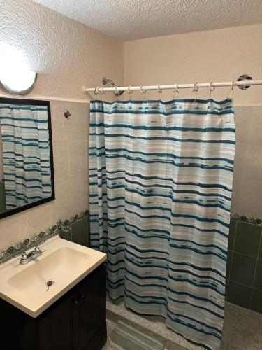 y baño con cortina de ducha y lavamanos. en Suite POKTAPOK en Cancún