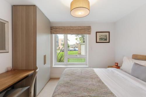 1 dormitorio con cama y ventana en Modern 3BR Flat quick links to LDN & Heathrow, en Shepperton