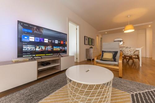 uma sala de estar com uma grande televisão de ecrã plano em Xenon Urban Apartments em Maputo