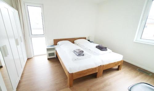 a bed in a room with white walls and wooden floors at Ferienwohnung Trave - Wohlfühlatmosphäre zum Auftanken in Bad Oldesloe