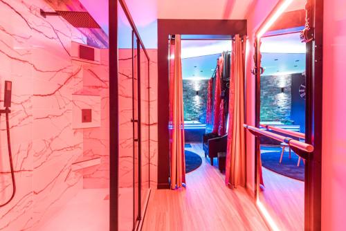 une pièce avec des murs roses et un mur en pierre dans l'établissement Love room au bord de l'eau. L'instant coquin, à Rochefort-sur-Loire