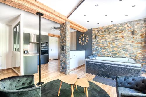 Il dispose d'une cuisine et d'un salon avec un mur en briques. dans l'établissement Love room au bord de l'eau. L'instant coquin, à Rochefort-sur-Loire