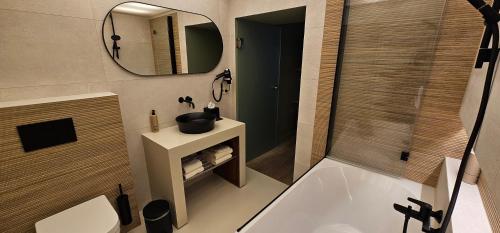 a bathroom with a tub and a sink and a mirror at Guesthouse Bonheure in Bruges