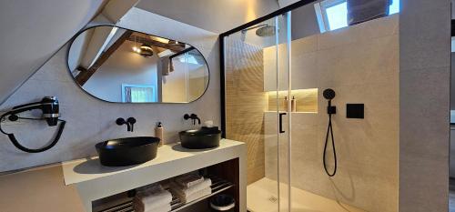 a bathroom with a sink and a shower with a mirror at Guesthouse Bonheure in Bruges
