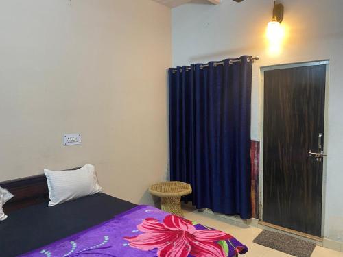 a bedroom with a bed and a blue curtain at Ram Paying Guest House & Hostel Near by Krishna Janmabhoomi GROUP OF MANAVI in Mathura