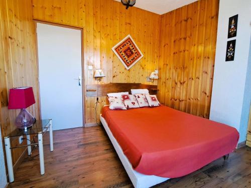 une chambre avec un lit avec une couette rouge dans l'établissement Grand T3 avec terrasse, équipement complet et accès direct galerie commerciale à Pra-Loup 1600 - FR-1-165A-54, à Uvernet