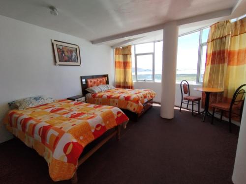 ein Hotelzimmer mit 2 Betten, einem Tisch und Stühlen in der Unterkunft INKA'S DREAMS HOUSE in Puno