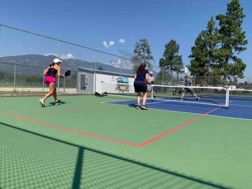 eine Gruppe von Leuten, die Tennis auf einem Tennisplatz spielen in der Unterkunft The Piper Pad in Canal Flats