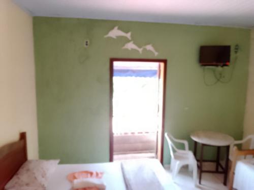a bedroom with a bed and a window with birds on the wall at Canto do mar in Paraty