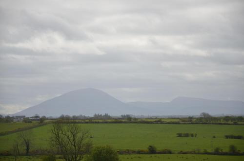 a green field with a hill in the distance at Enniscrone Luxury Double Room in Enniscrone