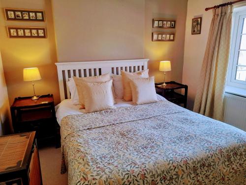 a bedroom with a large bed with white pillows at Robin Cottage in Pickering