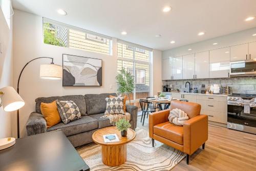 ein Wohnzimmer mit einem Sofa und Stühlen sowie eine Küche in der Unterkunft Perch - Urban View Haven in Seattle