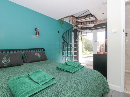 - une chambre avec un lit vert et des serviettes vertes dans l'établissement The Boar, à Blakeney
