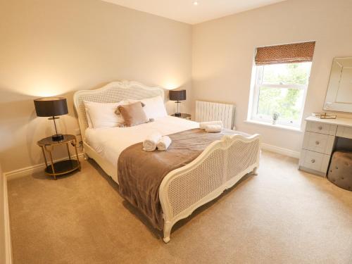 1 dormitorio con cama blanca y ventana en Foremans Cottage, en Hull