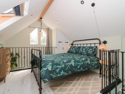 een slaapkamer met een bed met een groen dekbed bij The Deer in Blakeney