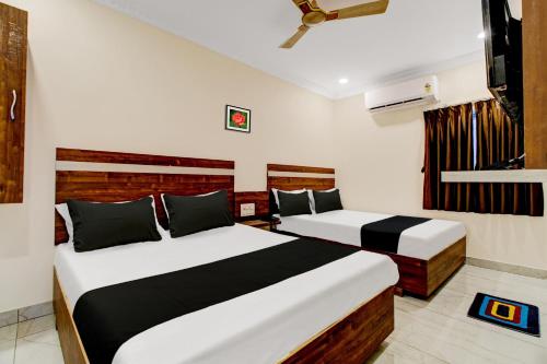 um quarto de hotel com duas camas e uma janela em OYO Hotel Leela Elite em Vijayawada