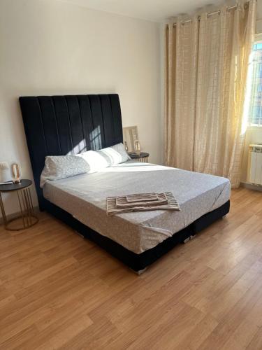 a bedroom with a large bed with a black headboard at Casa rural con jardín y piscina in Val de Santo Domingo