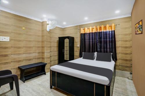 a bedroom with a bed and a chair in it at OYO Flagship Hotel Shiva Inn in Jamshedpur